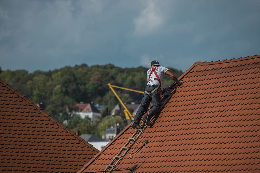 Team of roofers are shown replacing the roof of a house